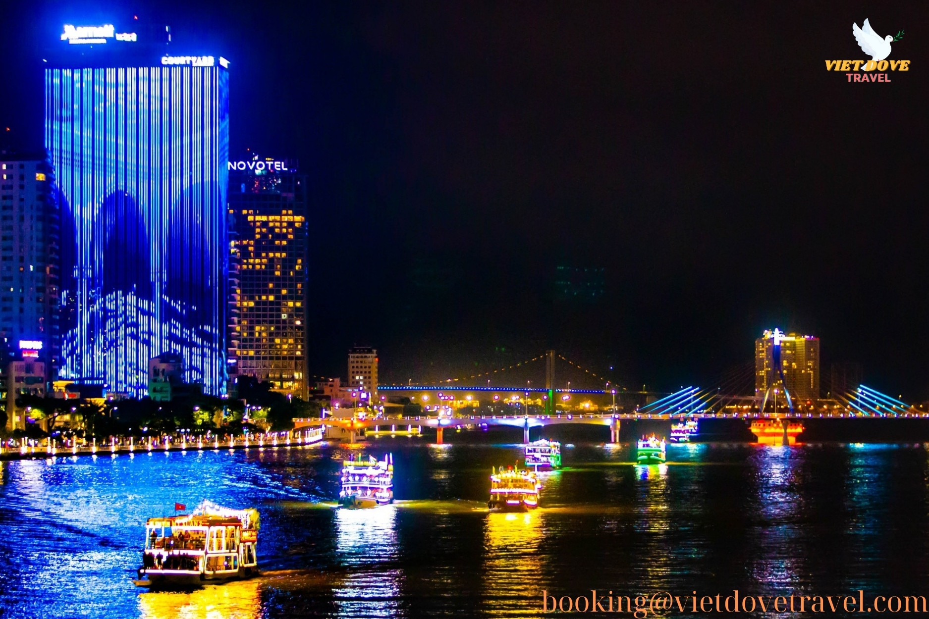 Colorful cruise boats light up the Han River at night in Da Nang, Vietnam